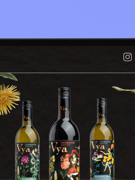 Two hands holding a tablet that shows the website homepage of Vya Vermouth on the screen